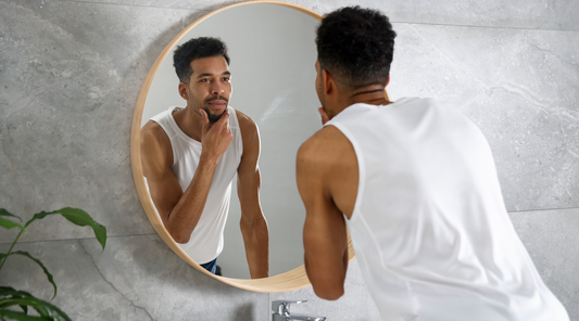 Man looking at his face in the mirror